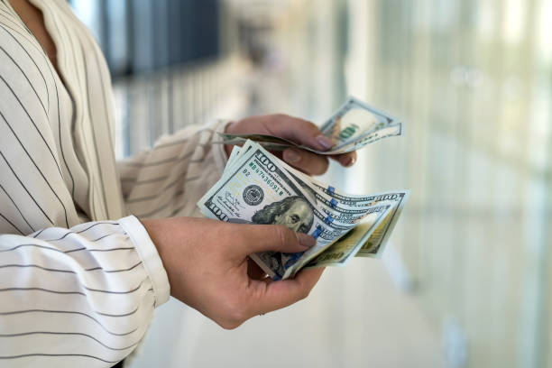 istock woman transfers dollars in the mall after successful purchase 1287243003