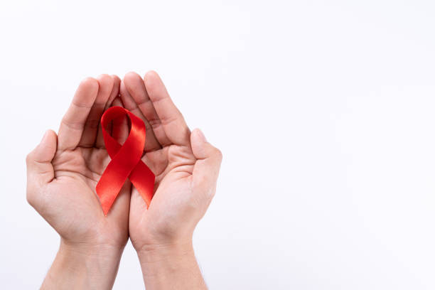 istock Aids awareness, man hands holding red ribbon on white background with copy space for text. World Aids Day, Healthcare and medical concept. 1287243122