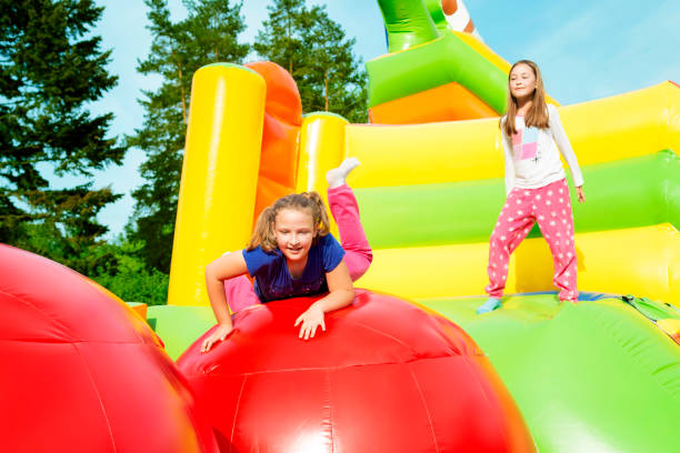 istock Two Girls Jumping on Inflate Castle 1287243321