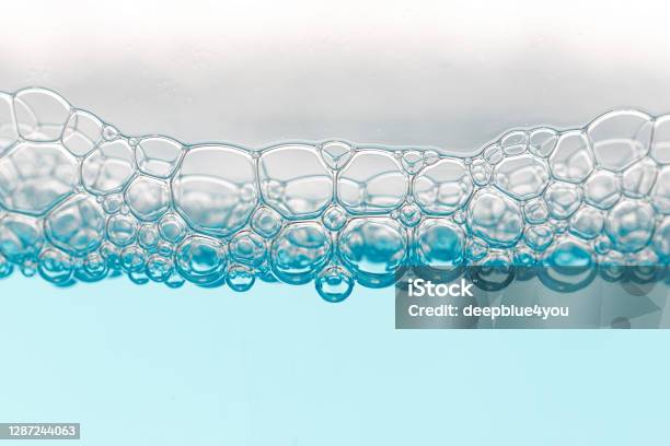 Detail Of Soap Bubbles In Clear Blue Liquid Background Stock Photo - Download Image Now