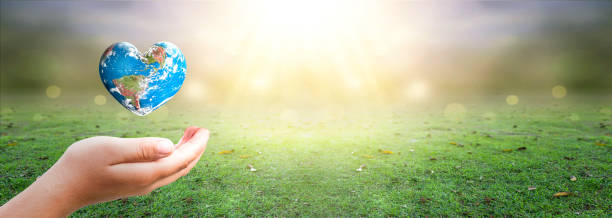 istock hand holding Heart shaped earth globe and  over blurred nature background. Elements of this image furnished by NASA 1287244262