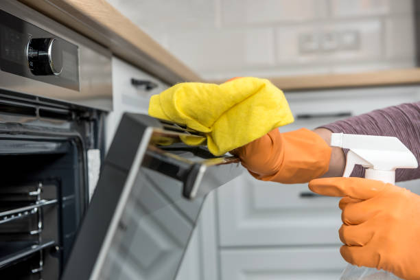 istock Man's hand in gloves cleaning the kitchen oven 1287244488