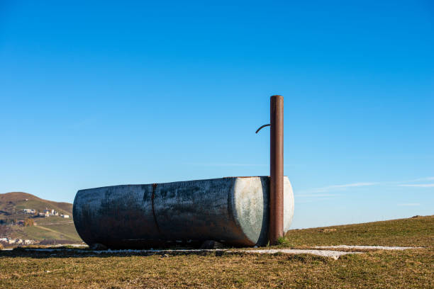 Closeup of a metal drinking trough for cows on clear sky on the Lessinia Plateau (Altopiano della Lessinia), Alps, Verona Province, Veneto, Italy, Europe.