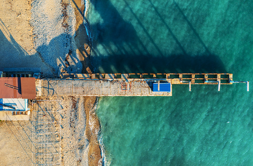 Aerial top view of old concrete pier, black sea coast, view from above.