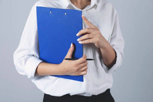 istock business Woman holds a blue folder. 1287245867