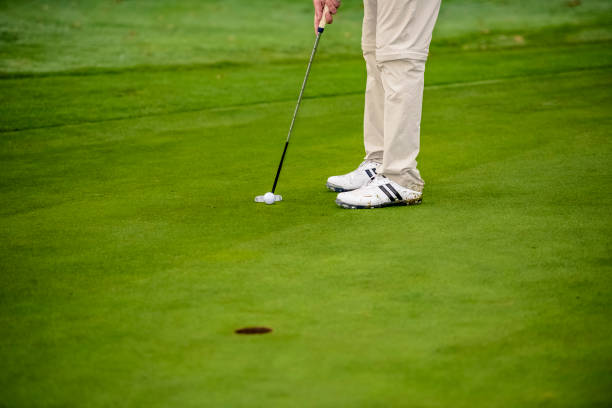 istock With a putt, hit the hole with the golf ball 1287247198