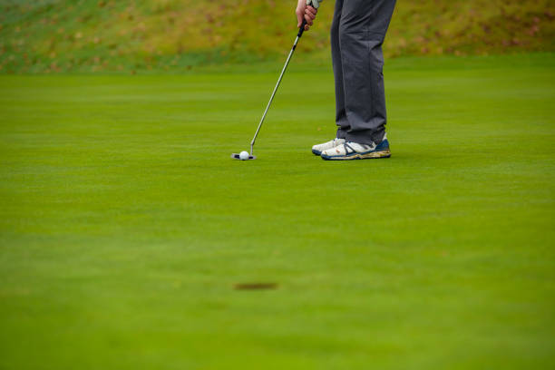 istock With a putt, hit the hole with the golf ball 1287247248