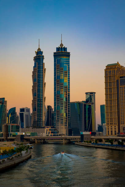 vista al tramonto della dubai water canal business bay. una barca che attraversa il canale con moderni grattacieli e un cielo colorato sullo sfondo. - united arab emirates foto e immagini stock