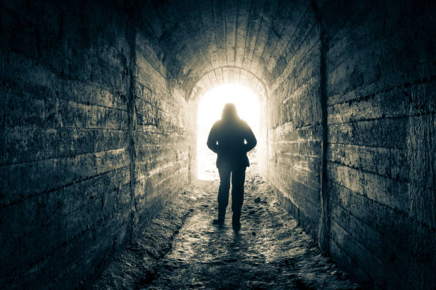 istock The man walks down the tunnel towards the light. 1287249030