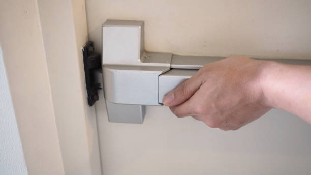 istock Hand is pushing Fire door handle of Fire exit for emergency evacuation. 1287249065
