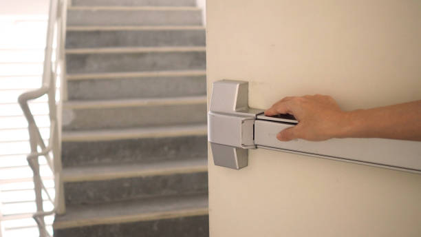 hand is pushing fire door handle of fire exit for emergency evacuation. - emergency exit imagens e fotografias de stock