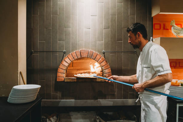 istock Pizza chef baking a pizza in the oven 1287249464