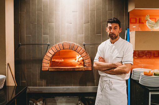 Portrait of a pizza chef inside his pizzeria