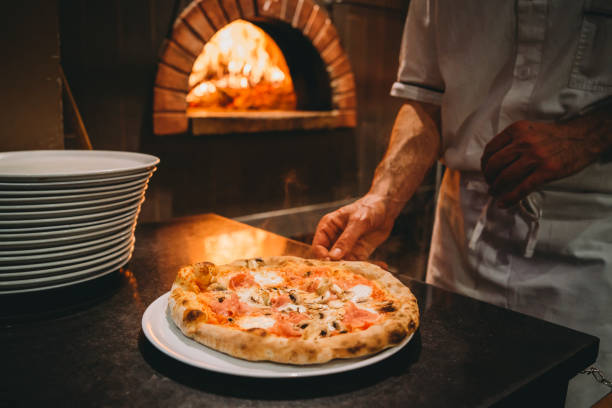 pizzaiolo prepara la pizza al ristorante - pizzeria foto e immagini stock