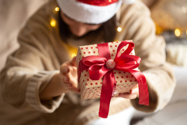 istock Christmas gift close up in female hands on a blurred background. 1287249519