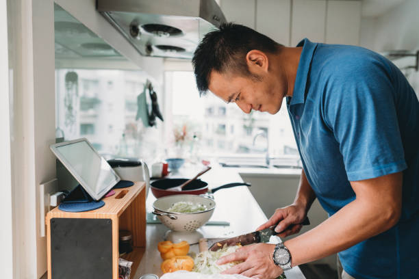 istock Man preparing dinner in the kitchen watching a recipe on the tablet 1287249557