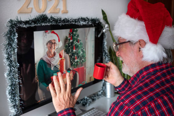 istock Coronavirus. Two smiling senior people with Santa hats in video call with computer for Christmas. Old active retirees addicted with new technologies. Lockdown due to coronavirus covid-19 1287252304