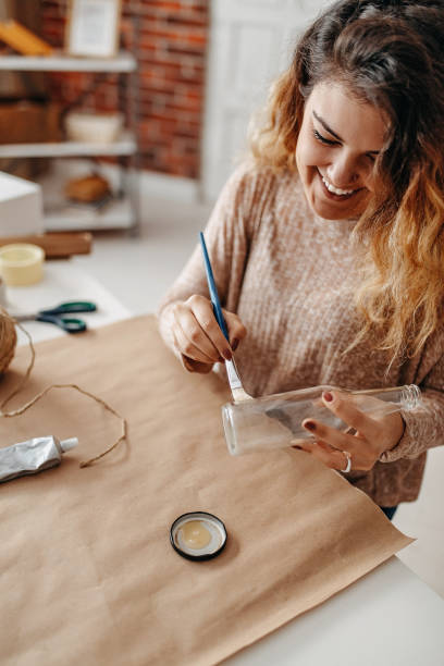 istock Do it yourself, the girl at home decorates a glass bottle 1287255607