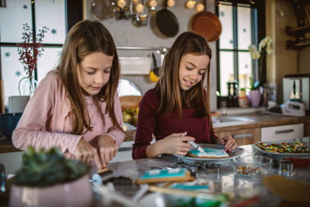 istock Girls decorate Gingerbread house 1287258507