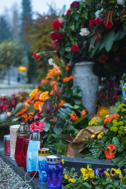 istock Face mask on a candle next to a fresh grave in the cemetery. 1287258564