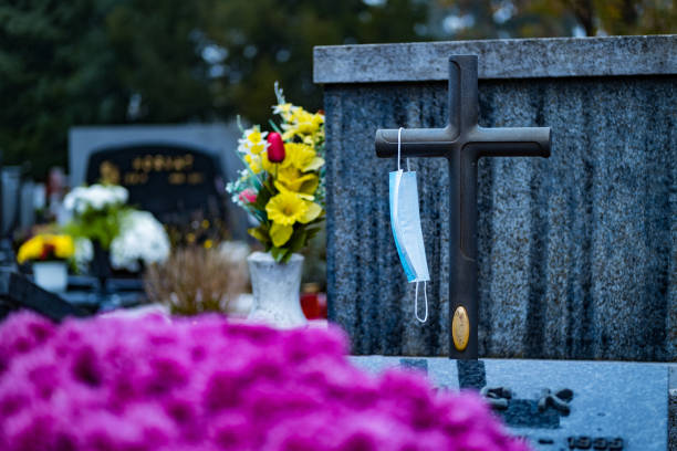 istock Coronavirus death. Face mask on a cross in the cemetery. 1287258628