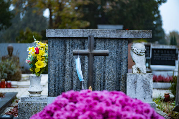 istock Coronavirus death. Face mask on a cross in the cemetery. 1287258774