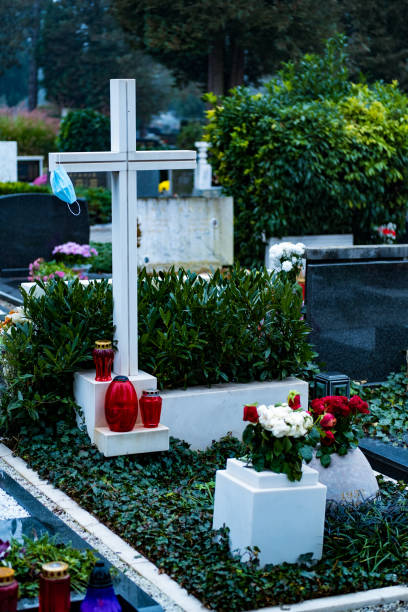 istock Coronavirus grave. Face mask on a white cross in the cemetery. 1287259952