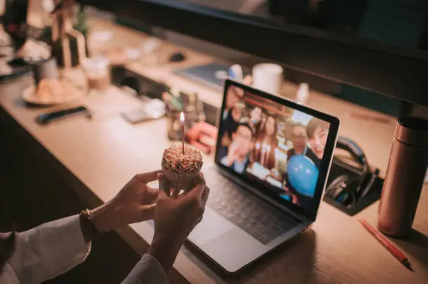 Photo of asian chinese beautiful woman alone working late in office celebrating her birthday video conference with her colleague at other branch