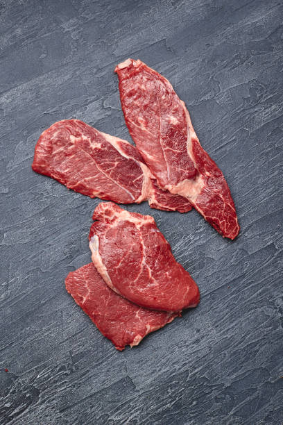 istock Raw meat beef steak on black top view. 1287260101