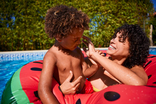 istock Mother helping boy with water on eye in a pool 1287263135