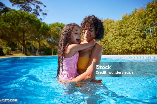 Photo libre de droit de Fille Sur Le Tour De Mère À Lintérieur De La Piscine En Été banque d'images et plus d'images libres de droit de Piscine