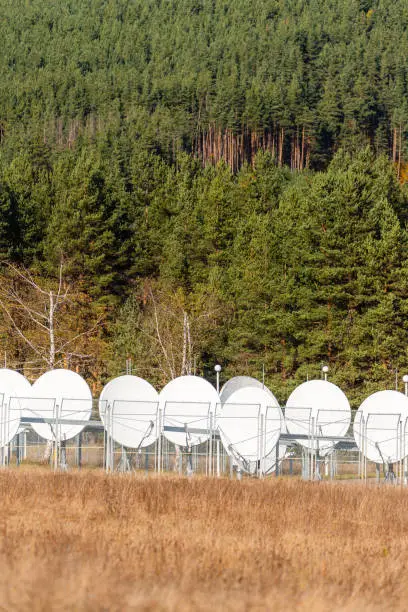 Satellite dish array communication base cell tower among autumn forest vibrant rural modern sunny day bulgaria copy space for text