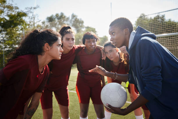 Female soccer players listening to their coach before game Group of female soccer players listening to their african-american female coach before game coach stock pictures, royalty-free photos & images