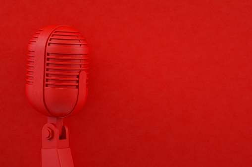 Old style microphone on red background. Vintage concept.