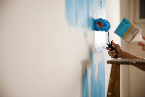 istock Couple repainting the white wall into blue color 1287268217