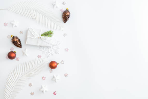 istock Flat lay frame with christmas baubles decoration, snowflakes and gift box on a white background 1287271984