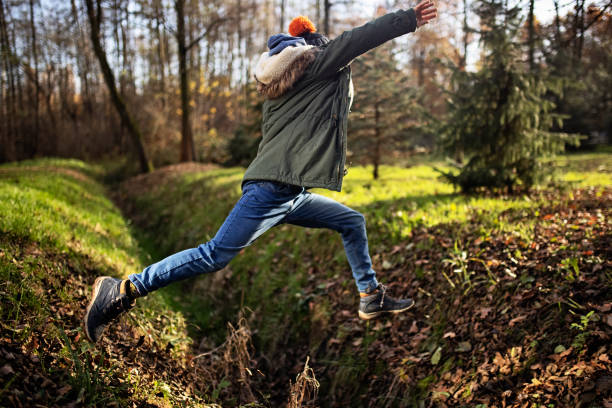 Boy jumping over ditch in autumn forest Boy is jumping over a ditch.
Shot with Canon R5 ditch stock pictures, royalty-free photos & images