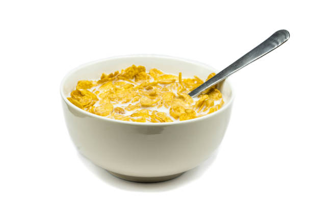 istock Corn flakes with milk in bowl isolated on white background 1287273495