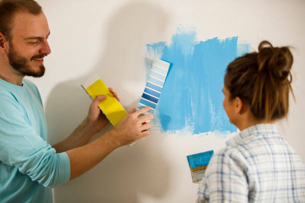 istock Comparing color swatch to a paint on the wall 1287274342