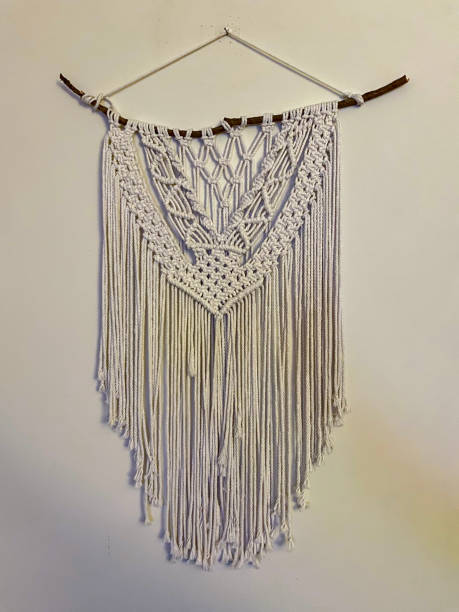 istock Handmade stylish cotton macrame decoration hanging on a white empty wall. 1287274846