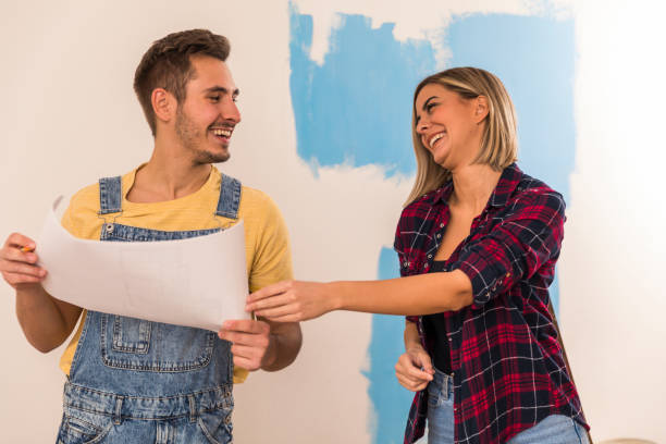 istock Couple looking at documents and planning house renovation 1287276113