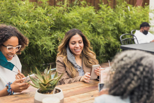 istock During COVID-19, friends remove masks to take selfies 1287276502