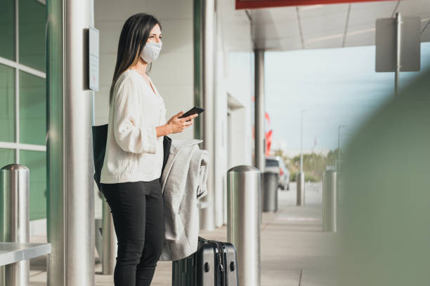 istock Standing outside terminal, woman waits for ride 1287276651