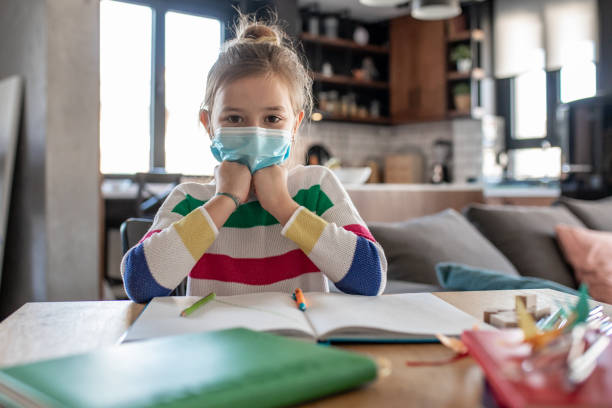 istock Young girl with protective mask at home, learning 1287277487