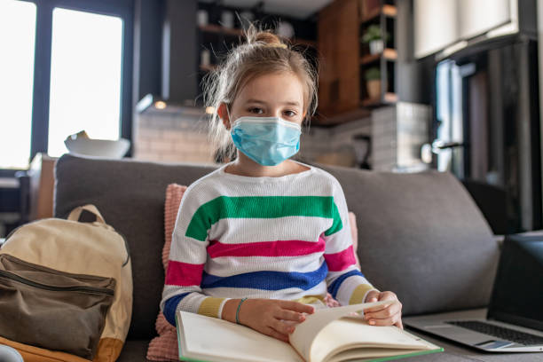 istock Young girl with protective mask at home, learning 1287277829