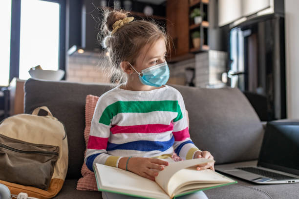 istock Young girl with protective mask at home, learning 1287277850