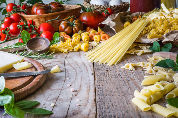 istock Abstract background ingredients for making pasta with various pasta on a wooden rustic table. Italian food 1287281340
