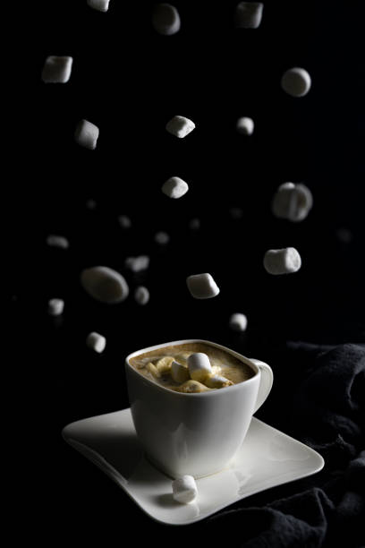istock Cup of coffee and marshmallows on black background 1287282612