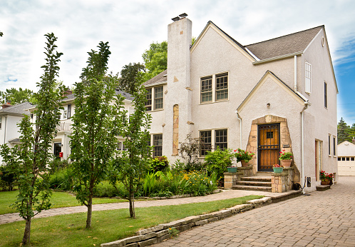 A residential home exterior. front view with lawn and garden.
