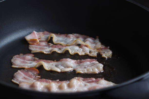 istock Bacon slices being fried in frying pan. 1287284287
